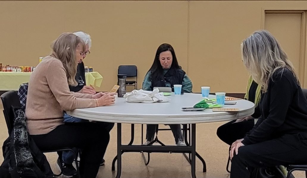 A group of people sitting around a table playing bingo