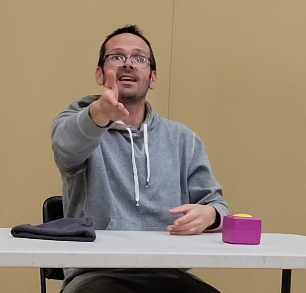 A man with mouth agape pointing at the camera