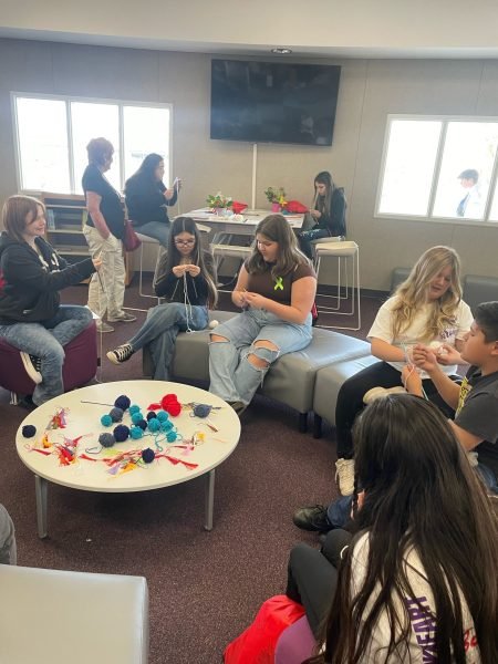 A group of people sitting in a circle knitting